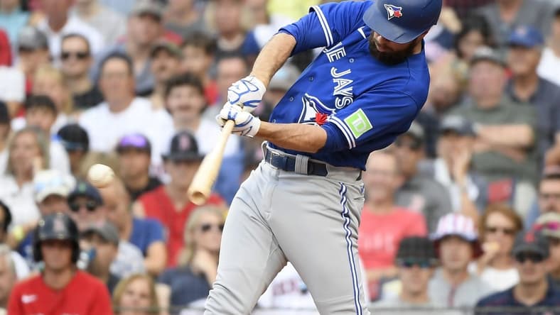 Aug 5, 2023; Boston, Massachusetts, USA;  Toronto Blue Jays designated hitter Brandon Belt (13) hits an RBI single during the sixth inning against the Boston Red Sox at Fenway Park. Mandatory Credit: Bob DeChiara-USA TODAY Sports