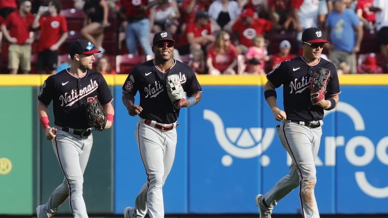 Aug 5, 2023; Cincinnati, Ohio, USA; Washington Nationals outfielders Lane Thomas (left) Stone Garrett (middle) and  Alex Call (right) run off the field after the Nationals defeated the Cincinnati Reds at Great American Ball Park. Mandatory Credit: David Kohl-USA TODAY Sports