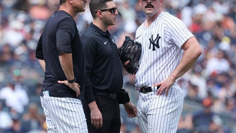 Aug 6, 2023; Bronx, New York, USA; New York Yankees starting pitcher Carlos Rodon (55) talks with medical staff and manager Aaron Boone (17) after an injury during the third inning against the Houston Astros at Yankee Stadium. Mandatory Credit: Vincent Carchietta-USA TODAY Sports