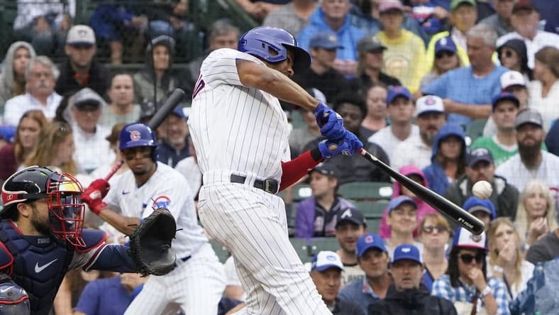 Aug 6, 2023; Chicago, Illinois, USA; Chicago Cubs first baseman Jeimer Candelario (9) hits a one run single against the Atlanta Braves during the fifth inning at Wrigley Field. Mandatory Credit: David Banks-USA TODAY Sports