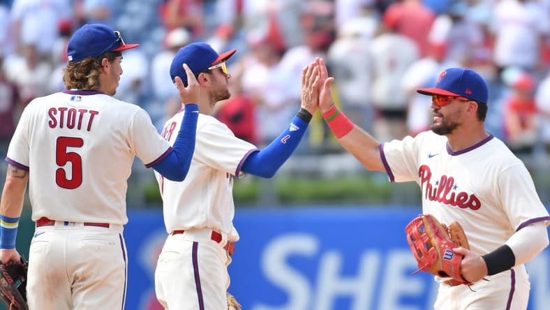 Aug 6, 2023; Philadelphia, Pennsylvania, USA; Philadelphia Phillies left fielder Kyle Schwarber (12) high fives shortstop Trea Turner (7) and second baseman Bryson Stott (5) as the celebrate win against the Kansas City Royals at Citizens Bank Park. Mandatory Credit: Eric Hartline-USA TODAY Sports