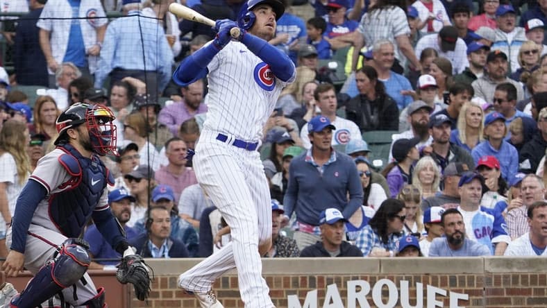 Aug 6, 2023; Chicago, Illinois, USA; Chicago Cubs center fielder Cody Bellinger (24) hits a single against the Atlanta Braves during the seventh inning at Wrigley Field. Mandatory Credit: David Banks-USA TODAY Sports