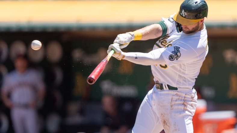 Aug 6, 2023; Oakland, California, USA;  Oakland Athletics left fielder Seth Brown (15) hits an RBI triple during the first inning against the San Francisco Giants at Oakland-Alameda County Coliseum. Mandatory Credit: Stan Szeto-USA TODAY Sports