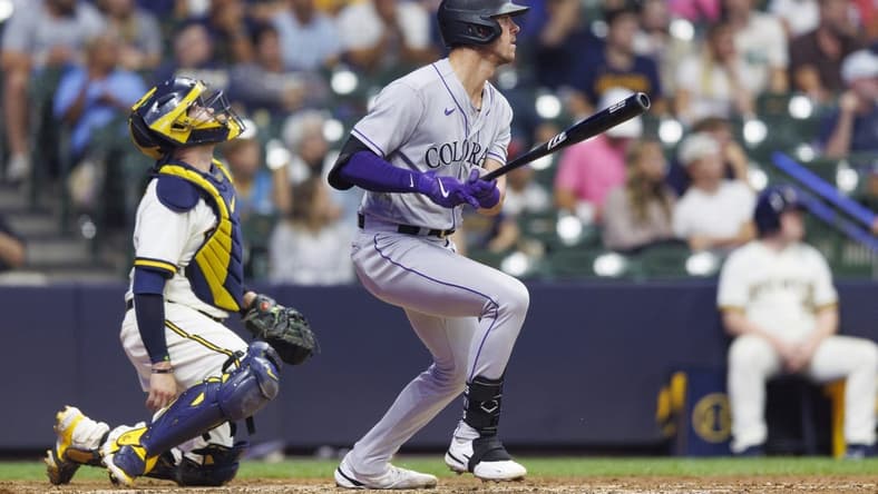 Aug 8, 2023; Milwaukee, Wisconsin, USA;  Colorado Rockies left fielder Nolan Jones (22) hits a sacrifice fly ball during the tenth inning against the Milwaukee Brewers at American Family Field. Mandatory Credit: Jeff Hanisch-USA TODAY Sports