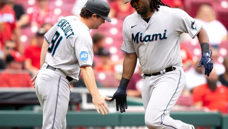 Miami Marlins first baseman Josh Bell (9) greets Miami Marlins quality assurance coach Griffin Benedict (81) after hitting a solo home run in the fourth inning of the MLB baseball game between Cincinnati Reds and Miami Marlins at Great American Ball Park in Cincinnati on Wednesday, Aug. 9, 2023.