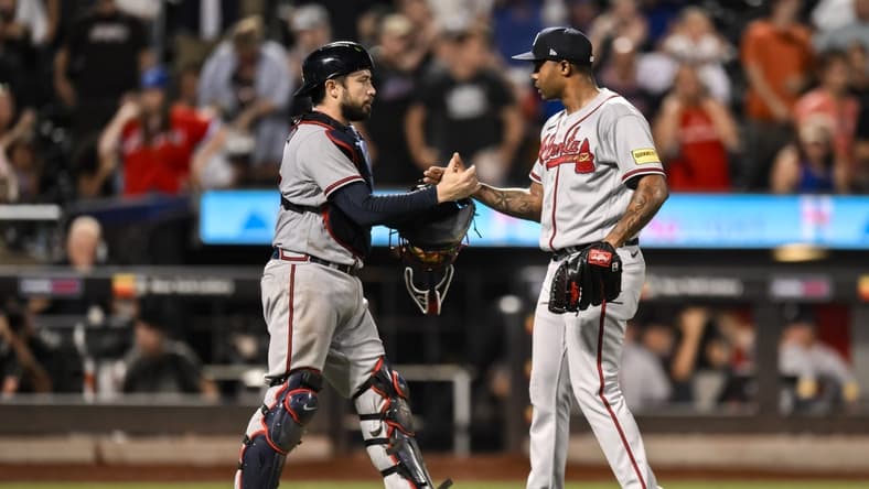 Aug 12, 2023; New York City, New York, USA; Atlanta Braves catcher Travis d'Arnaud (16) and Atlanta Braves relief pitcher Raisel Iglesias (26) shake hands after winning 6-0 against the New York Mets at Citi Field. Mandatory Credit: John Jones-USA TODAY Sports