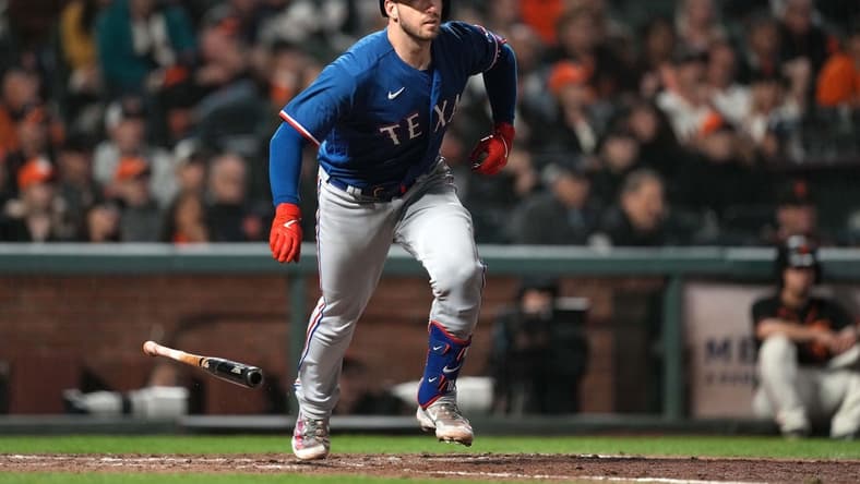 Aug 12, 2023; San Francisco, California, USA; Texas Rangers catcher Mitch Garver (18) runs to first base after hitting an RBI single against the San Francisco Giants during the ninth inning at Oracle Park. Mandatory Credit: Darren Yamashita-USA TODAY Sports