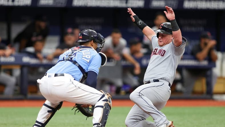 Aug 13, 2023; St. Petersburg, Florida, USA;  Cleveland Guardians first baseman Kole Calhoun (56) scores a run past Tampa Bay Rays catcher Christian Bethancourt (14) in the third inning at Tropicana Field. Mandatory Credit: Nathan Ray Seebeck-USA TODAY Sports