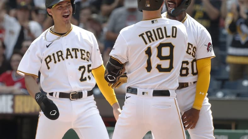 Aug 13, 2023; Pittsburgh, Pennsylvania, USA; Pittsburgh Pirates catcher Endy Rodriguez (25) and shortstop Liover Peguero (60) congratulate pinch hitter Jared Triolo (19) at home plate after Triolo hit a three run home run to record his first major league home run against the Cincinnati Reds during the seventh inning at PNC Park. Mandatory Credit: Charles LeClaire-USA TODAY Sports