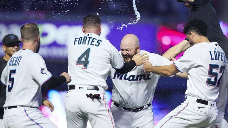 Aug 13, 2023; Miami, Florida, USA; Miami Marlins third baseman Jake Burger (36) celebrates with catcher Nick Fortes (4), relief pitcher Jorge Lopez (52), and shortstop Jon Berti (5) after hitting a walk-off single against the New York Yankees at loanDepot Park. Mandatory Credit: Sam Navarro-USA TODAY Sports