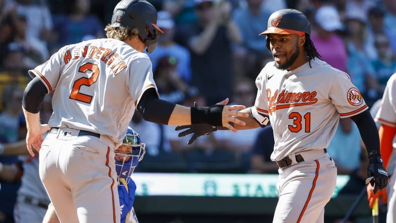 Aug 13, 2023; Seattle, Washington, USA; Baltimore Orioles center fielder Cedric Mullins (31) reacts with shortstop Gunnar Henderson (2) after hitting a two-run home run against the Seattle Mariners during the tenth inning at T-Mobile Park. Henderson scored a run on the hit. Mandatory Credit: Joe Nicholson-USA TODAY Sports