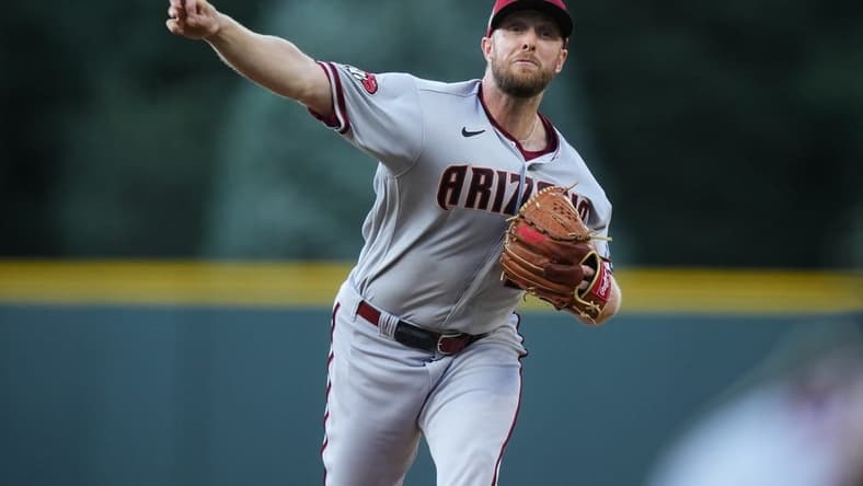 Aug 14, 2023; Denver, Colorado, USA; Arizona Diamondbacks starting pitcher Merrill Kelly (29) delivers a pitch in the first inning against the Colorado Rockies at Coors Field. Mandatory Credit: Ron Chenoy-USA TODAY Sports