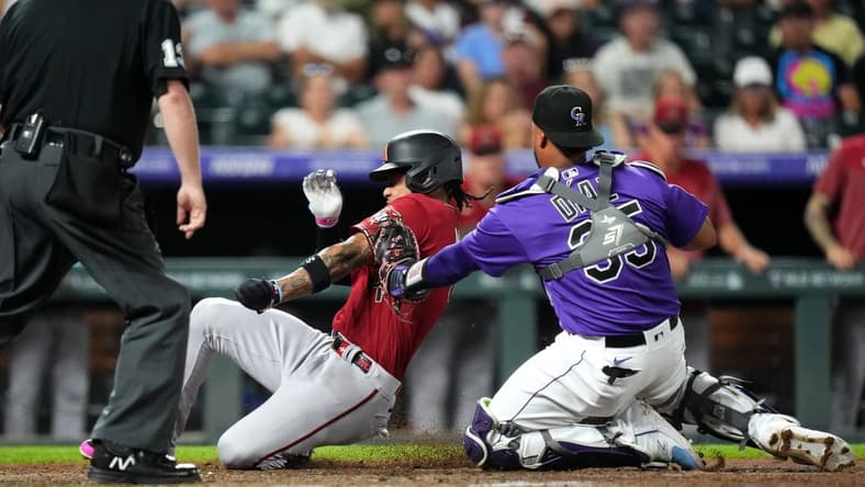 Aug 15, 2023; Denver, Colorado, USA; Colorado Rockies catcher Elias Diaz (35) tags out Arizona Diamondbacks second baseman Ketel Marte (4) in the seventh inning at Coors Field. Mandatory Credit: Ron Chenoy-USA TODAY Sports