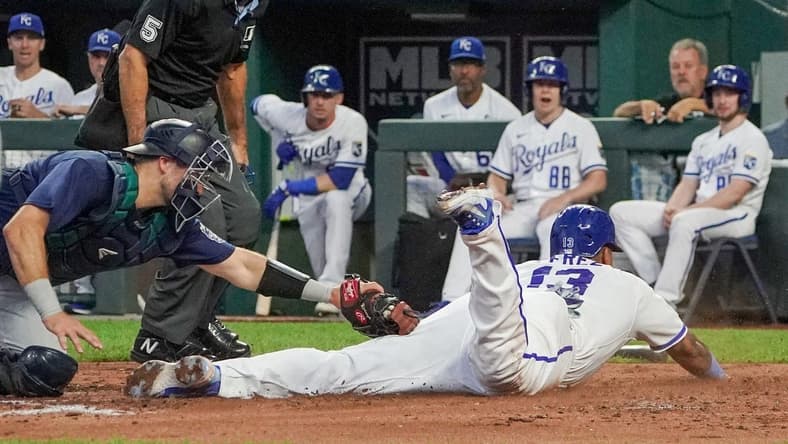 Aug 16, 2023; Kansas City, Missouri, USA; Seattle Mariners catcher Cal Raleigh (29) misses the tag as Kansas City Royals catcher Salvador Perez (13) scores in the third inning at Kauffman Stadium. Mandatory Credit: Denny Medley-USA TODAY Sports