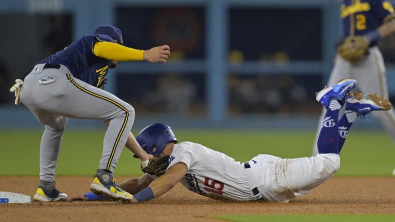 Aug 17, 2023; Los Angeles, California, USA;  Los Angeles Dodgers catcher Austin Barnes (15) beats the throw to Milwaukee Brewers shortstop Willy Adames (27) for a stolen base in the third inning at Dodger Stadium. Mandatory Credit: Jayne Kamin-Oncea-USA TODAY Sports