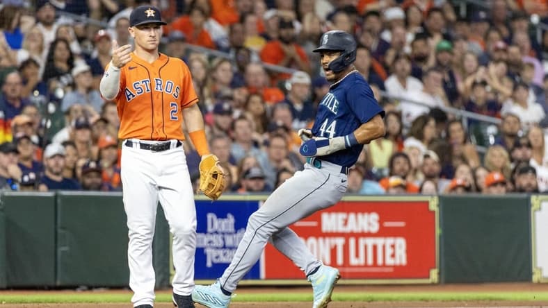 Aug 18, 2023; Houston, Texas, USA; Seattle Mariners center fielder Julio Rodriguez (44) runs from first base to third base on an error as Houston Astros third baseman Alex Bregman (2) awaits the throw in the seventh inning at Minute Maid Park. Mandatory Credit: Thomas Shea-USA TODAY Sports