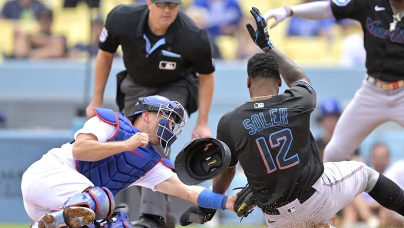 Aug 19, 2023; Los Angeles, California, USA;  Los Angeles Dodgers catcher Austin Barnes (15) tags Miami Marlins designated hitter Jorge Soler (12) out at home on a throw by Los Angeles Dodgers right fielder David Peralta (6) in the third inning at Dodger Stadium. Mandatory Credit: Jayne Kamin-Oncea-USA TODAY Sports
