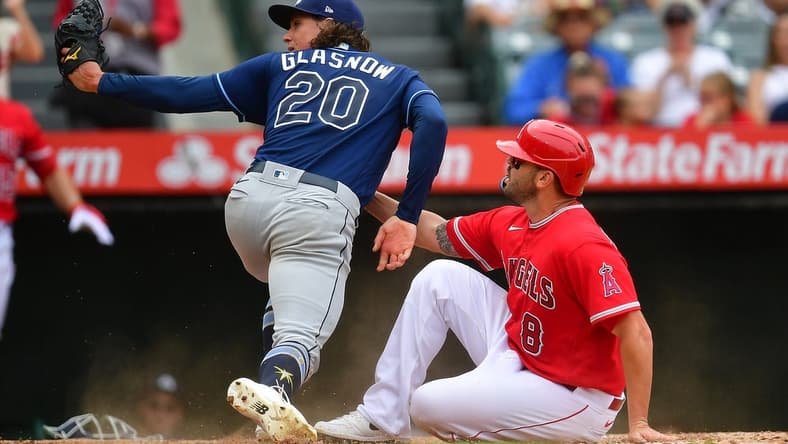 Aug 19, 2023; Anaheim, California, USA; Los Angeles Angels third baseman Mike Moustakas (8) scores a run against Tampa Bay Rays starting pitcher Tyler Glasnow (20) during the third inning at Angel Stadium. Mandatory Credit: Gary A. Vasquez-USA TODAY Sports