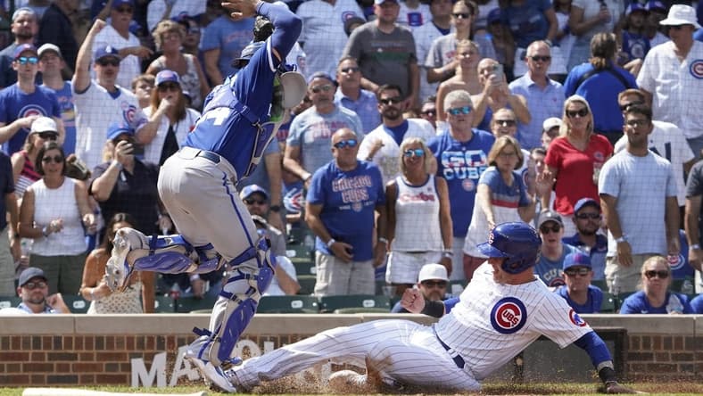 Aug 19, 2023; Chicago, Illinois, USA; Chicago Cubs catcher Yan Gomes (15) is safe at home plate as Kansas City Royals catcher Freddy Fermin (34) takes the throw during the fourth inning at Wrigley Field. Mandatory Credit: David Banks-USA TODAY Sports
