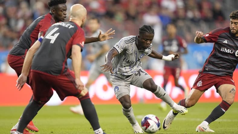 Aug 20, 2023; Toronto, Ontario, CAN; CF Montr  al forward Kwadwo Opoku (90) controls the ball while defended by several Toronto FC players during the first half at BMO Field. Mandatory Credit: John E. Sokolowski-USA TODAY Sports