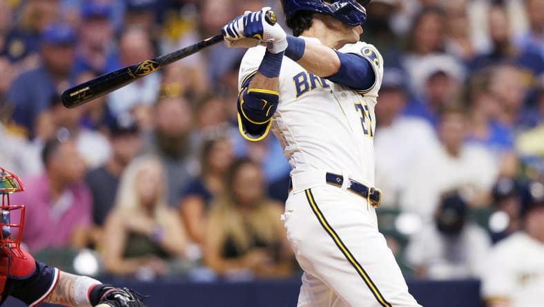 Aug 22, 2023; Milwaukee, Wisconsin, USA; Milwaukee Brewers left fielder Christian Yelich (22) hits a double during the third inning against the Minnesota Twins at American Family Field. Mandatory Credit: Jeff Hanisch-USA TODAY Sports