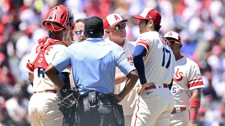 Aug 23, 2023; Anaheim, California, USA; Los Angeles Angels manager Phil Nevin (center) meets with starting pitcher Shohei Ohtani (17) at the mound during the second inning against the Cincinnati Reds at Angel Stadium. Mandatory Credit: Orlando Ramirez-USA TODAY Sports