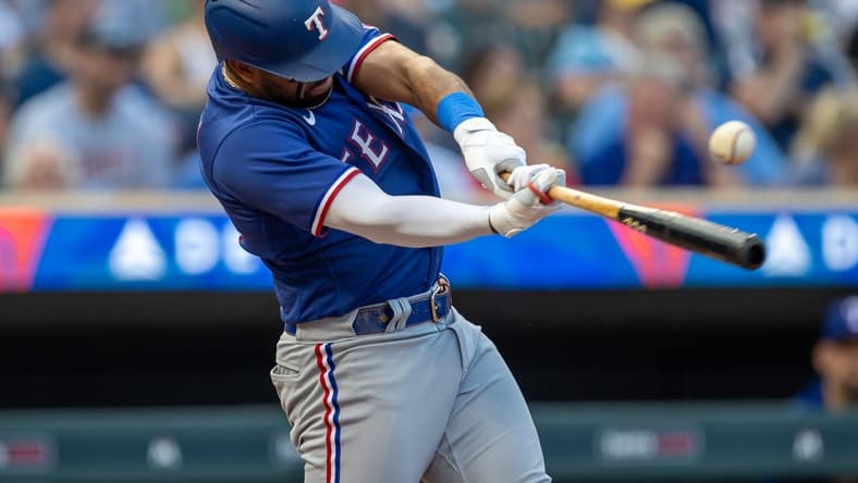 Aug 24, 2023; Minneapolis, Minnesota, USA; Texas Rangers third baseman Ezequiel Duran (20) hits a single against the Minnesota Twins in the second inning at Target Field. Mandatory Credit: Jesse Johnson-USA TODAY Sports