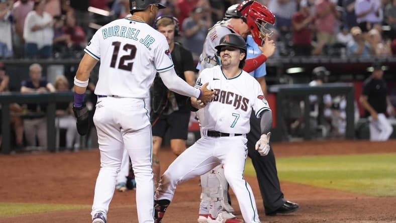 Aug 24, 2023; Phoenix, Arizona, USA; Arizona Diamondbacks center fielder Corbin Carroll (7) celebrates his two run home run with Arizona Diamondbacks left fielder Lourdes Gurriel Jr. (12) against the Cincinnati Reds during the eighth inning at Chase Field. Mandatory Credit: Joe Camporeale-USA TODAY Sports