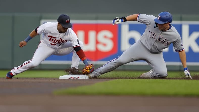 Aug 25, 2023; Minneapolis, Minnesota, USA; Texas Rangers shortstop Corey Seager (5) beats the tag of Minnesota Twins second baseman Jorge Polanco (11) for a double in the first inning at Target Field. Mandatory Credit: Bruce Kluckhohn-USA TODAY Sports