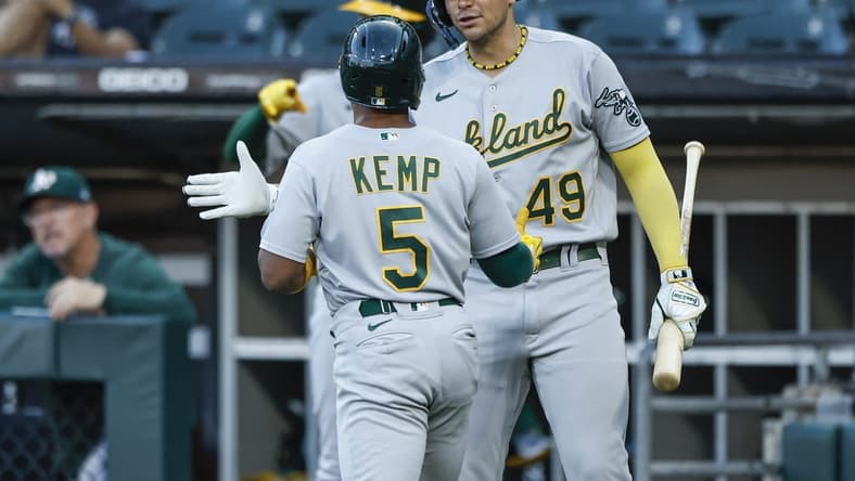 Aug 25, 2023; Chicago, Illinois, USA; Oakland Athletics second baseman Tony Kemp (5) celebrates with first baseman Ryan Noda (49) after scoring against the Chicago White Sox during the second inning at Guaranteed Rate Field. Mandatory Credit: Kamil Krzaczynski-USA TODAY Sports