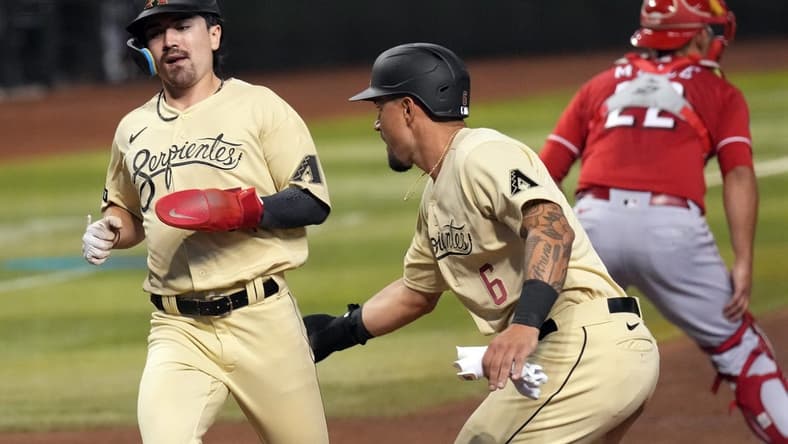 Aug 25, 2023; Phoenix, Arizona, USA; Arizona Diamondbacks third baseman Jace Peterson (6) celebrates with Arizona Diamondbacks left fielder Corbin Carroll (7) after scoring runs against the Cincinnati Reds during the fourth inning at Chase Field. Mandatory Credit: Joe Camporeale-USA TODAY Sports