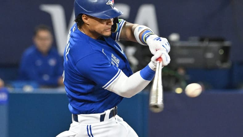 Aug 26, 2023; Toronto, Ontario, CAN; Toronto Blue Jays shortstop Santiago Espinal (5) hits an RBI double against the Cleveland Guardians in the fourth inning at Rogers Centre. Mandatory Credit: Dan Hamilton-USA TODAY Sports