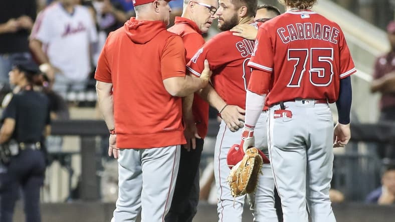 Aug 26, 2023; New York City, New York, USA; Los Angeles Angels starting pitcher Chase Silseth (63) is checked on after getting hit in the head by a throw in the fourth inning against the New York Mets at Citi Field. Mandatory Credit: Wendell Cruz-USA TODAY Sports