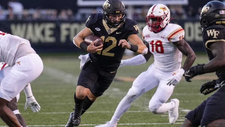 Sep 1, 2022; Winston-Salem, North Carolina, USA; Wake Forest Demon Deacons quarterback Mitch Griffis (12) runs past Virginia Military Institute Keydets linebacker Jason Johnson (18) during the first half at Truist Field. Mandatory Credit: Jim Dedmon-USA TODAY Sports