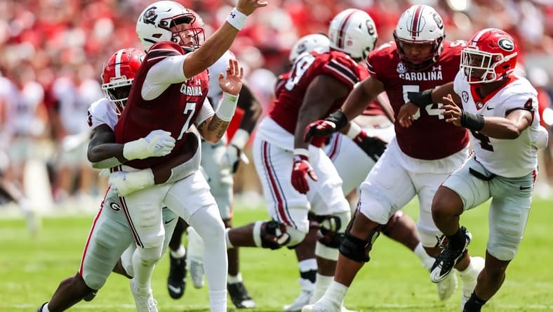 Sep 17, 2022; Columbia, South Carolina, USA; South Carolina Gamecocks quarterback Spencer Rattler (7) passes as he is hit by Georgia Bulldogs defensive lineman Mykel Williams (13) in the second quarter at Williams-Brice Stadium. Mandatory Credit: Jeff Blake-USA TODAY Sports