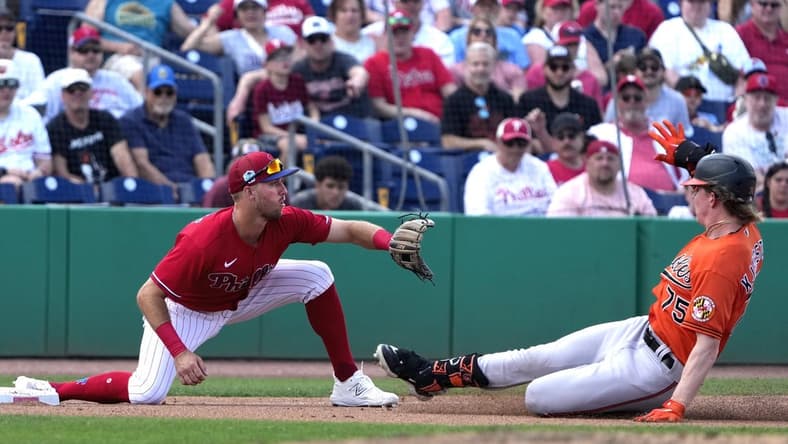Mar 9, 2023; Clearwater, Florida, USA;  Baltimore Orioles outfielder Heston Kjerstad (75) slides safely into third as Philadelphia Phillies third baseman Alec Bohm (28) waits for the ball during the seventh at BayCare Ballpark. Mandatory Credit: Dave Nelson-USA TODAY Sports