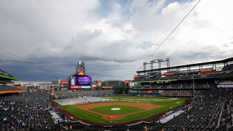 Jun 29, 2023; Denver, Colorado, USA; Grounds crew clear the infield tarp during a rain delay before the game between the Colorado Rockies and the Los Angeles Dodgers at Coors Field. Mandatory Credit: Isaiah J. Downing-USA TODAY Sports