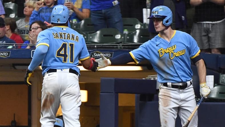 Aug 25, 2023; Milwaukee, Wisconsin, USA; Milwaukee Brewers first baseman Carlos Santana (41) scores a run against the San Diego Padres and is congratulated by Milwaukee Brewers left fielder Mark Canha (21) in the seventh inning at American Family Field. Mandatory Credit: Michael McLoone-USA TODAY Sports