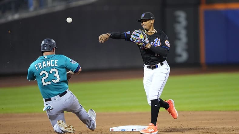 Sep 1, 2023; New York City, New York, USA; New York Mets shortstop Francisco Lindor (12) turns a double play with Seattle Mariners first baseman Ty France (23) sliding into second base during the second inning at Citi Field. Mandatory Credit: Gregory Fisher-USA TODAY Sports