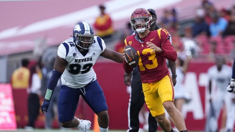 Sep 2, 2023; Los Angeles, California, USA; Southern California Trojans quarterback Caleb Williams (13) is pressured by Nevada Wolf Pack defensive end Dion Washington (92) in the second half at United Airlines Field at Los Angeles Memorial Coliseum. Mandatory Credit: Kirby Lee-USA TODAY Sports