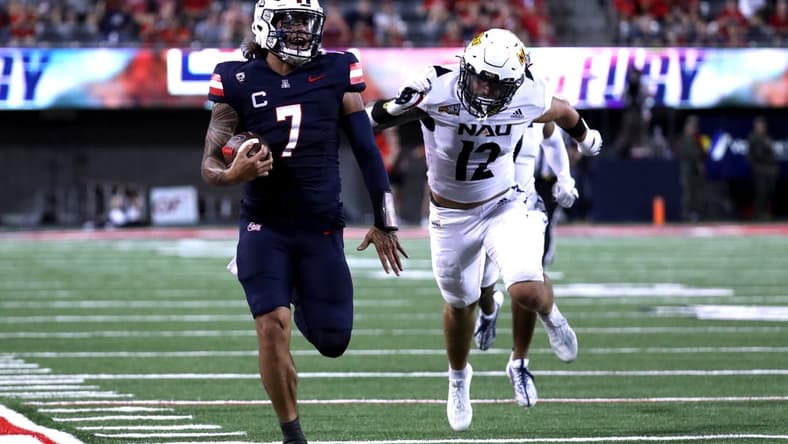 Sep 2, 2023; Tucson, Arizona, USA; Arizona Wildcats quarterback Jayden de Laura (7) runs for a touchdown agaisnt Northern Arizona Lumberjacks defensive back Jeff Widener (12) during the second half at Arizona Stadium. Mandatory Credit: Zac BonDurant-USA TODAY Sports