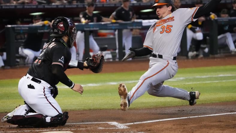 Sep 3, 2023; Phoenix, AZ, USA; Arizona Diamondbacks catcher Jose Herrera (11) tags out Baltimore Orioles' Adley Rutschman (35) at Chase Field.
