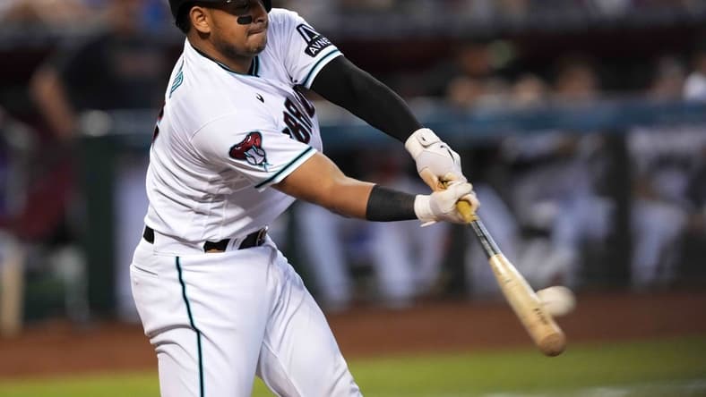 Sep 4, 2023; Phoenix, Arizona, USA; Arizona Diamondbacks catcher Gabriel Moreno (14) hits an RBI single against the Colorado Rockies during the fourth inning at Chase Field. Mandatory Credit: Joe Camporeale-USA TODAY Sports