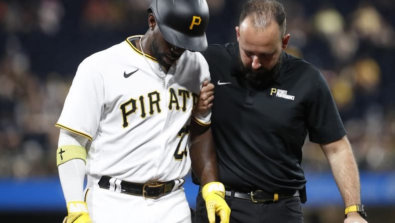Sep 4, 2023; Pittsburgh, Pennsylvania, USA;  Pittsburgh Pirates designated hitter Andrew McCutchen (22) is helped from the field after suffering an apparent injury against the Milwaukee Brewers during the fifth inning at PNC Park. Mandatory Credit: Charles LeClaire-USA TODAY Sports