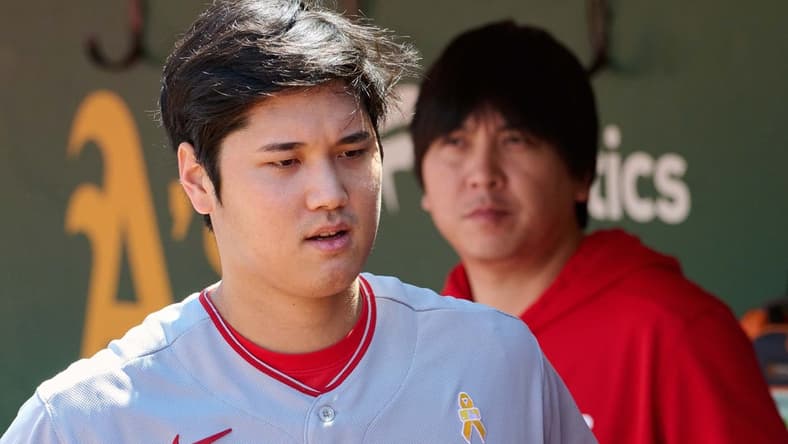 Sep 3, 2023; Oakland, California, USA; Los Angeles Angels designated hitter Shohei Ohtani (17) and interpreter Ippei Mizuhara stand in the dugout before the game between the Los Angeles Angels and the Oakland Athletics at Oakland-Alameda County Coliseum. Mandatory Credit: Robert Edwards-USA TODAY Sports