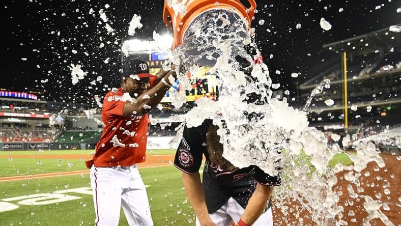 Sep 6, 2023; Washington, District of Columbia, USA; Washington Nationals outfielder Jacob Young (30) is doused with water by Washington Nationals outfielder Victor Robles (16) after hitting a walk off RBI single against the New York Mets during the ninth inning at Nationals Park. Mandatory Credit: Brad Mills-USA TODAY Sports