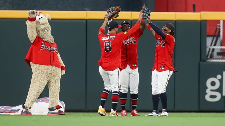 Sep 8, 2023; Atlanta, Georgia, USA; Atlanta Braves mascot Blooper and left fielder Eddie Rosario (8) and center fielder Michael Harris II (23) and right fielder Ronald Acuna Jr. (13) celebrate after a victory against the Pittsburgh Pirates at Truist Park. Mandatory Credit: Brett Davis-USA TODAY Sports
