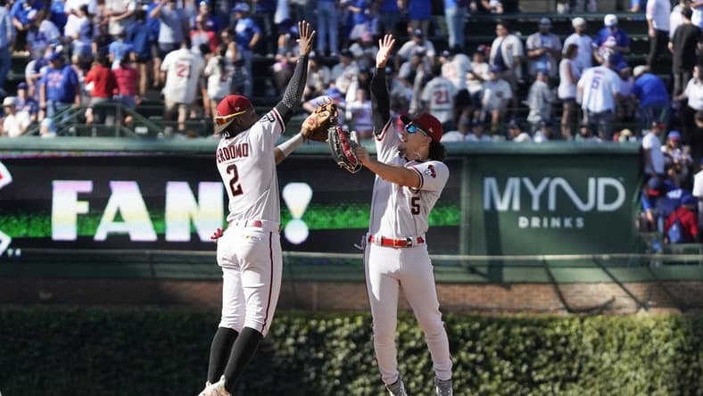 Sep 9, 2023; Chicago, Illinois, USA; Arizona Diamondbacks second baseman Geraldo Perdomo (2) and outfielder Alek Thomas (5) celebrate their win against the Chicago Cubs at Wrigley Field. Mandatory Credit: David Banks-USA TODAY Sports