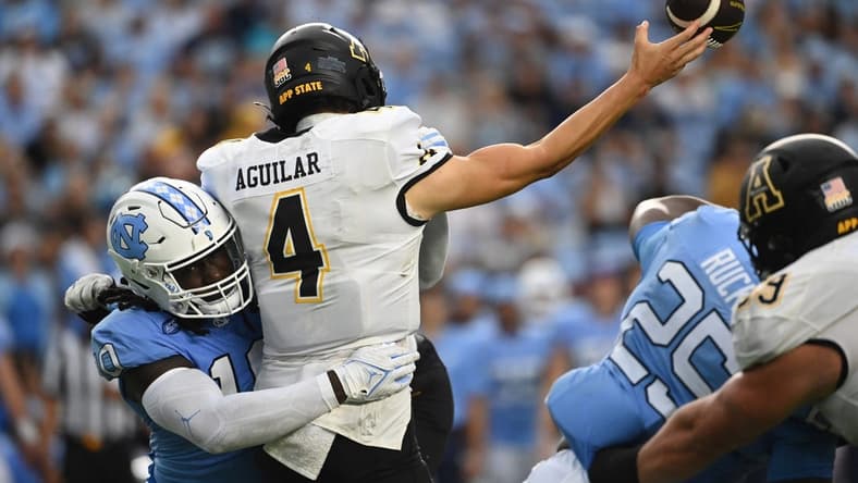 Sep 9, 2023; Chapel Hill, North Carolina, USA; Appalachian State Mountaineers quarterback Joey Aguilar (4) passes the ball as North Carolina Tar Heels defensive lineman Desmond Evans (10) pressures in the second quarter at Kenan Memorial Stadium. Mandatory Credit: Bob Donnan-USA TODAY Sports