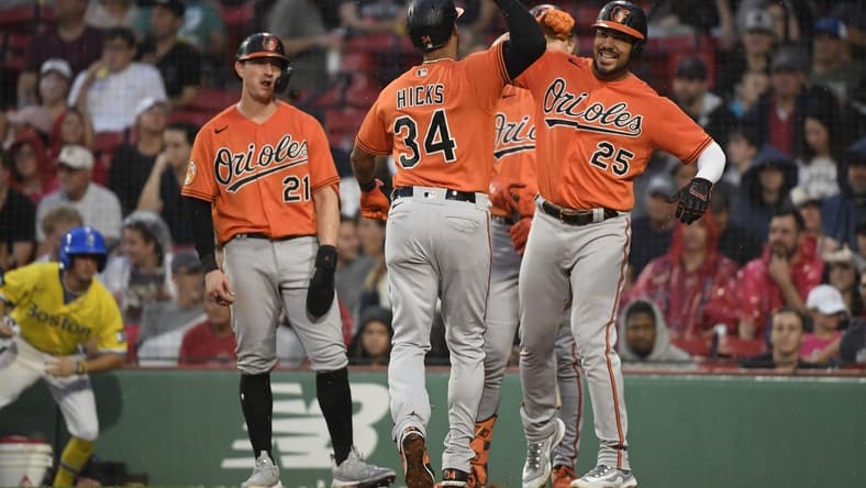 Sep 9, 2023; Boston, Massachusetts, USA;  Baltimore Orioles center fielder Aaron Hicks (34) is greeted at home plate by right fielder Anthony Santander (25) after hitting a three run home run during the third inning against the Boston Red Sox at Fenway Park. Mandatory Credit: Bob DeChiara-USA TODAY Sports
